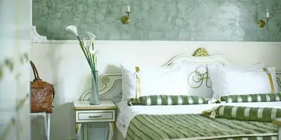 a bedroom with two beds and a vase on a table at Queen's Astoria Design Hotel in Belgrade