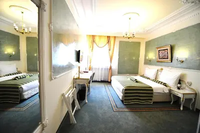 a hotel room with two beds and a window at Queen's Astoria Design Hotel in Belgrade