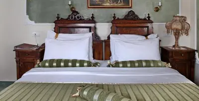 a bedroom with a large bed with wooden headboards at Queen's Astoria Design Hotel in Belgrade