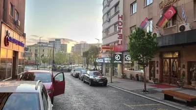 a city street with cars parked on the street at Queen's Astoria Design Hotel in Belgrade