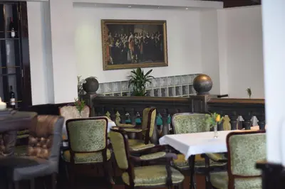 a dining room with a table and chairs and a bench at Queen's Astoria Design Hotel in Belgrade