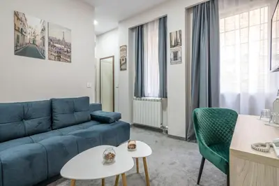 a living room with a blue couch and green chairs at Veneti Suites in Belgrade