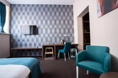 a bedroom with a bed and a desk and a chair at Veneti Suites in Belgrade