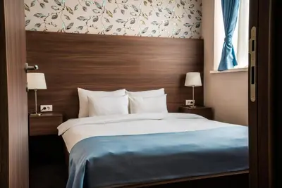 a bedroom with a large bed with a wooden headboard at Veneti Suites in Belgrade