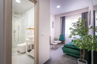 a bathroom with a bed and a sink and a toilet at Veneti Suites in Belgrade