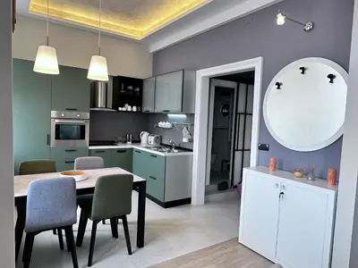 a kitchen with a table and chairs in a room at Broz Apartment in Belgrade