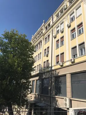 a large building with a tree in front of it at Broz Apartment in Belgrade