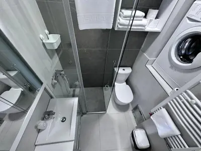 a small bathroom with a shower and a washing machine at Broz Apartment in Belgrade