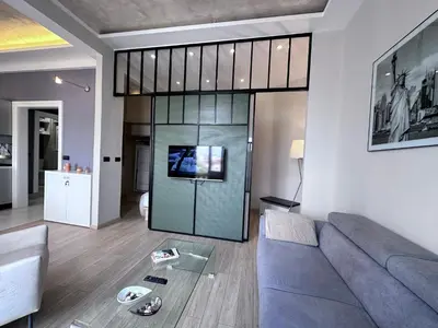 a living room with a couch and a glass wall at Broz Apartment in Belgrade