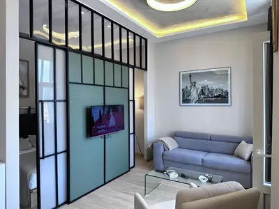 a living room with a blue couch and a sliding glass door at Broz Apartment in Belgrade