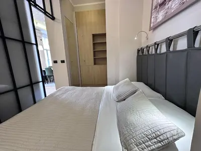 a bedroom with a large bed and a large window at Broz Apartment in Belgrade