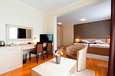 a hotel room with a bed and a living room at Garni Hotel Nevski in Belgrade