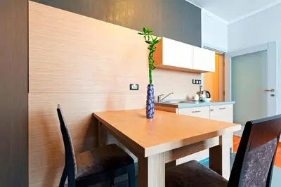 a kitchen with a wooden table with a vase on it at Garni Hotel Nevski in Belgrade