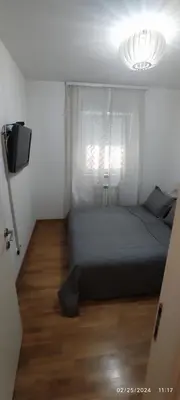 a bedroom with a bed and a window and a television at Apartment Leonis in Belgrade