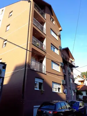 a tall building with cars parked in front of it at Apartment Leonis in Belgrade