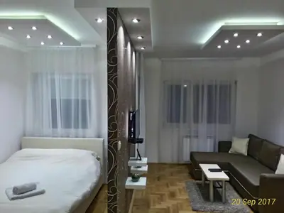 a bedroom and a living room with a bed and a couch at Apartment Frida in Belgrade