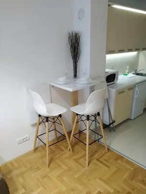 a kitchen with two white chairs and a table at Apartment Frida in Belgrade