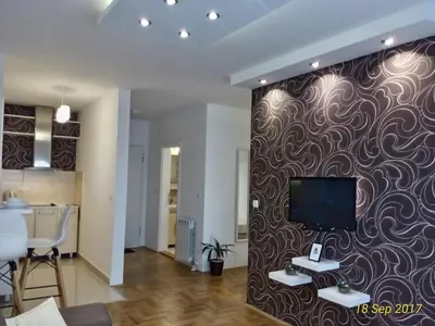 a living room with a tv on a wall at Apartment Frida in Belgrade