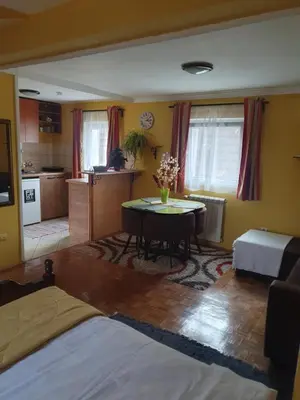 a living room with a table and a kitchen at Aerport - Natura Apartment in Belgrade