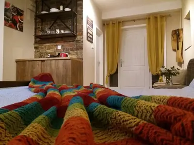 a bed with a colorful blanket on it in a room at Aerport - Natura Apartment in Belgrade