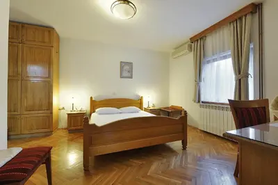 a bedroom with a bed and a table and a window at Hotel Sucevic Garni in Belgrade