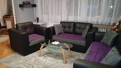 a living room with two couches and a glass table at Apartment Milos in Belgrade