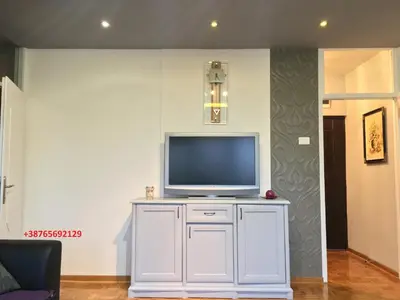 a television on a white cabinet in a living room at Apartment Milos in Belgrade