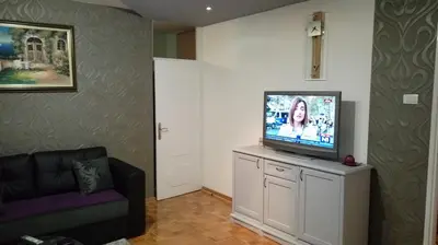 a living room with a flat screen tv on a cabinet at Apartment Milos in Belgrade