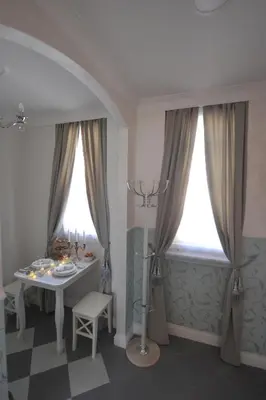a dining room with a table and two windows at Margot Luxury Studio in Belgrade