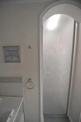 a bathroom with a mirror and a white wall at Margot Luxury Studio in Belgrade