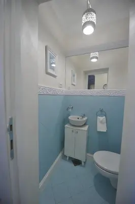 a blue bathroom with a toilet and a sink at Margot Luxury Studio in Belgrade