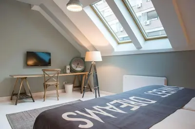 a attic bedroom with a bed and a desk at Smokvica Dorćol B&B in Belgrade