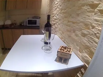 a white table with a bottle of wine and a glass at Double Decker Apartment in Belgrade