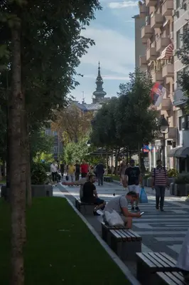 a group of people sitting on benches in a park at Double Decker Apartment in Belgrade