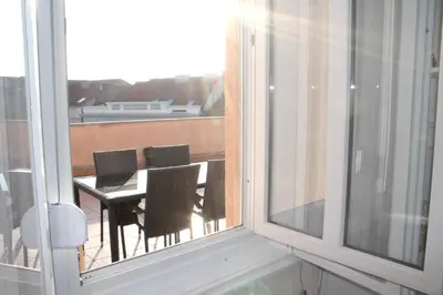 a balcony with a table and chairs and a window at Rooftop Apartment Belgrade in Belgrade