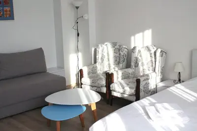 a living room with two chairs and a couch at Rooftop Apartment Belgrade in Belgrade