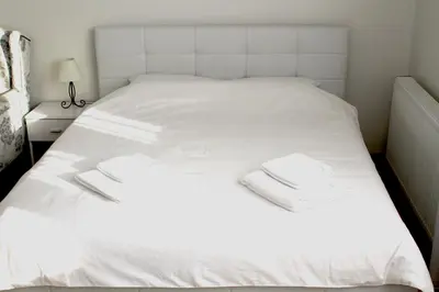 a white bed with two white towels on it at Rooftop Apartment Belgrade in Belgrade
