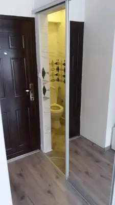 a bathroom with a toilet and a sliding glass door at White City 1 Apartment in Belgrade