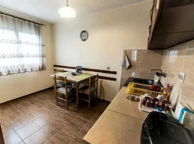 a kitchen with a table and a clock on the wall at Apartman Stankovic in Arandjelovac