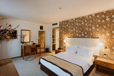 a hotel room with a large bed and a desk at Hotel 1000 Ruza in Belgrade