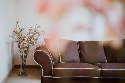 a brown couch sitting next to a vase with flowers at Hotel 1000 Ruza in Belgrade