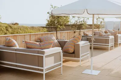 a row of couches and an umbrella on a patio at Hotel 1000 Ruza in Belgrade