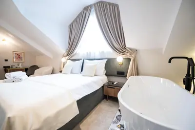 a hotel room with two beds and a bathtub at Boem Exclusive Rooms Skadarlija in Belgrade
