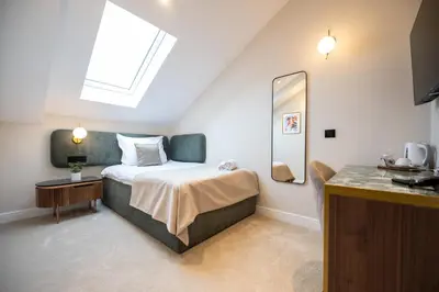 a bedroom with a bed with a mirror and a sink at Boem Exclusive Rooms Skadarlija in Belgrade