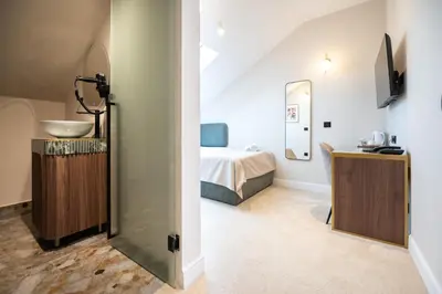 a bathroom with a sink and a bed in a room at Boem Exclusive Rooms Skadarlija in Belgrade