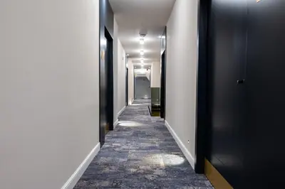 a long hallway with black doors and a carpet at Boem Exclusive Rooms Skadarlija in Belgrade