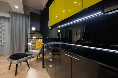 a kitchen with a black counter and yellow cabinets at Lella Apartment 2 - duplex - epicenter of Belgrade in Belgrade
