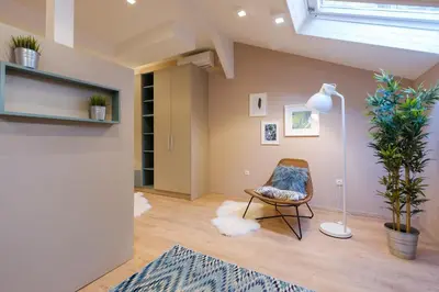 a living room with a chair and a floor lamp at Lella Apartment 2 - duplex - epicenter of Belgrade in Belgrade