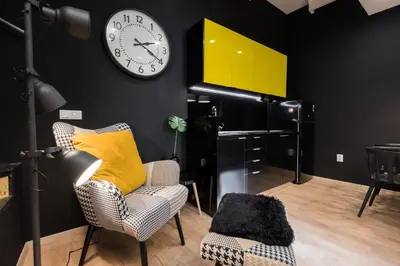 a room with a clock on the wall and a chair at Lella Apartment 2 - duplex - epicenter of Belgrade in Belgrade