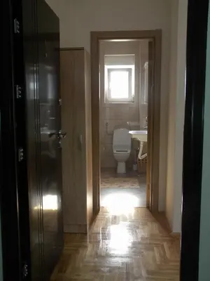 a bathroom with a toilet and a window and a door at Apartment Srebrni oblak in Arandjelovac